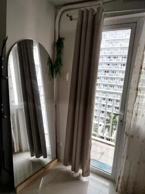 a room with a window with curtains and a view of a building at Dash Shell Residences in Manila