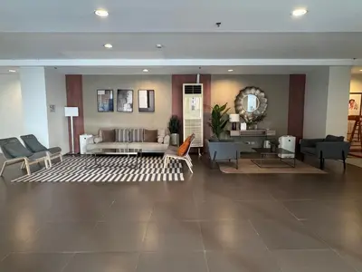 a living room with a couch and a table and chairs at Studio Unit Amaia Skies Shaw in Manila