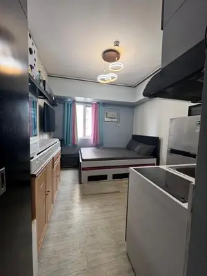 a kitchen with a bed in the middle of a room at Studio Unit Amaia Skies Shaw in Manila