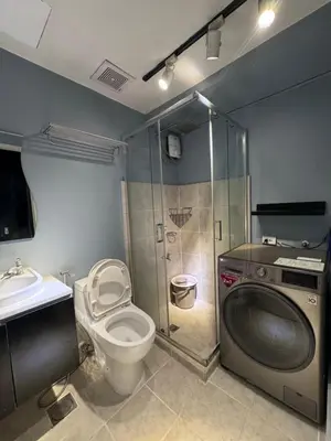 a bathroom with a shower and a toilet and a sink at Studio Unit Amaia Skies Shaw in Manila