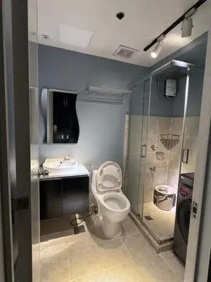 a bathroom with a toilet and a sink and a shower at Studio Unit Amaia Skies Shaw in Manila