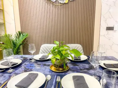a table with plates and a vase with a plant on it at Bayshore 9g 4br in Manila