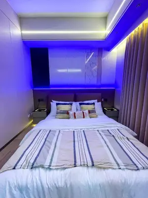 a bedroom with a large bed with purple lighting at Bayshore 9g 4br in Manila