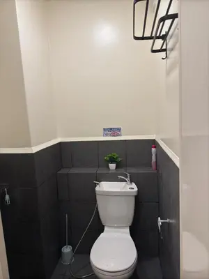 a bathroom with a toilet and a plant on the wall at Condo in Cubao by Cindy in Manila