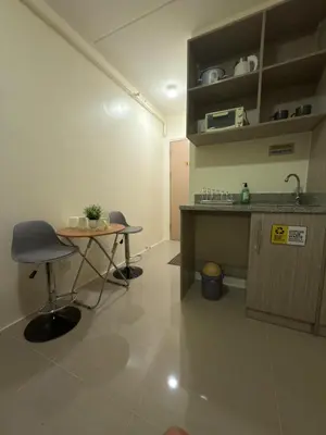 a room with a desk and a table and a sink at Condo in Cubao by Cindy in Manila
