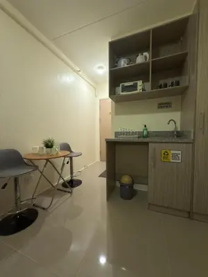 a kitchen with a table and a sink in a room at Condo in Cubao by Cindy in Manila