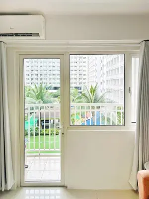 a sliding glass door with a view of a building at Shore Residences 2 Bedroom with Balcony Near NAIA Airport MOA in Manila