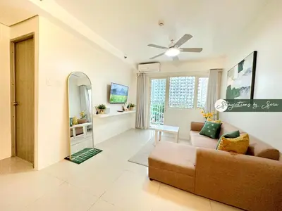 a living room with a couch and a ceiling fan at Shore Residences 2 Bedroom with Balcony Near NAIA Airport MOA in Manila