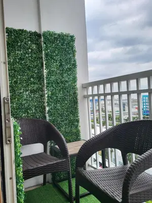 two chairs on a balcony with a green wall at Balay Maria in Manila