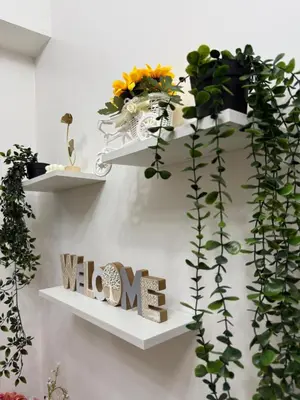 a white shelf with plants and a sign that says welcome at Casa Vigonia in Manila