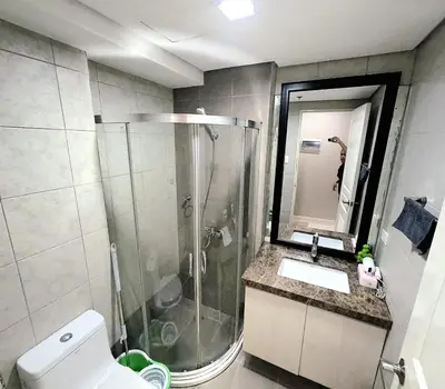 a bathroom with a shower and a toilet and a sink at Condotel nearby MOA with Pool Access in Manila
