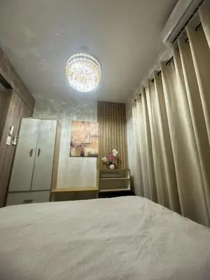 a bedroom with a large bed and a chandelier at Shore 2 Residence Homes Near MOA in Manila