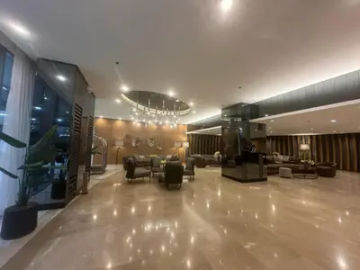a lobby with couches and chairs and a chandelier at Shore 2 Residence Homes Near MOA in Manila
