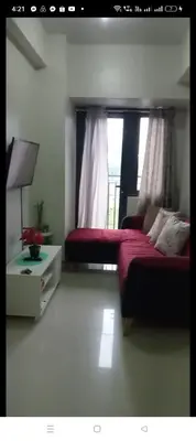 a bedroom with a red bed and a window at Shore 2 Residence Homes Near MOA in Manila