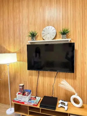 a flat screen tv hanging on a wooden wall at Mariels Staycation in Manila