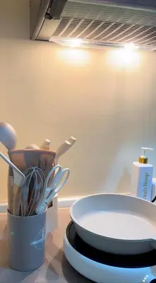 a counter top with a plate and a cup of utensils at Mariels Staycation in Manila