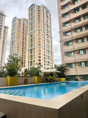 a swimming pool in front of tall buildings at Mariels Staycation in Manila