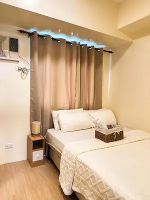 a bedroom with two beds and a window at Mariels Staycation in Manila