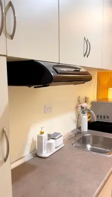 a kitchen counter with a sink and a microwave at Mariels Staycation in Manila