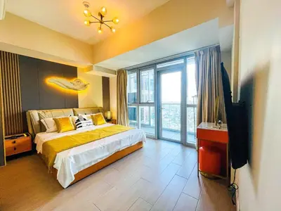 a bedroom with a bed and a large window at Luxury 2BR Penthouse Across Uptown BGC I Modern in Manila
