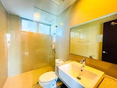 a bathroom with a sink and a toilet and a mirror at Ultra-Luxury 3BR Penthouse in Uptown BGC in Manila