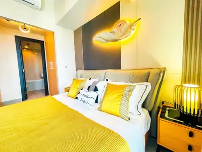 a bedroom with a bed with yellow and white pillows at Ultra-Luxury 3BR Penthouse in Uptown BGC in Manila