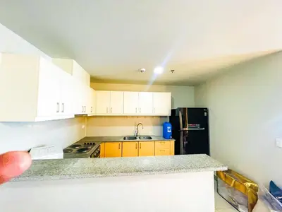 a kitchen with white cabinets and a black refrigerator at Ultra-Luxury 3BR Penthouse in Uptown BGC in Manila