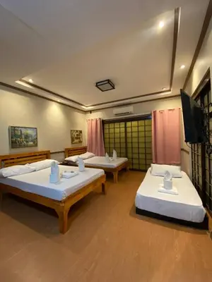 a room with two beds and a flat screen tv at P3k suites barkada family room in Manila