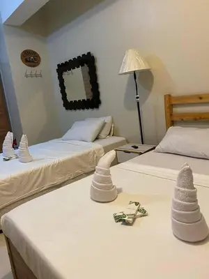 a room with two beds with sand castles on them at P3k suites barkada family room in Manila