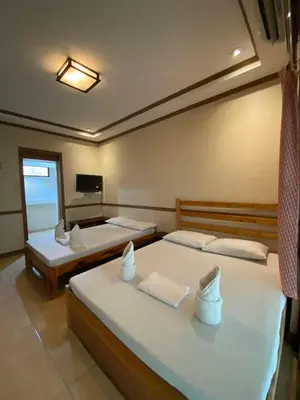 a bedroom with two beds and a television in it at P3k suites barkada family room in Manila