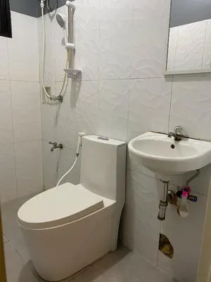 a bathroom with a toilet and a sink at P3k suites barkada family room in Manila