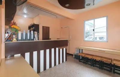 a kitchen with a counter and benches in a room at J and T Jamich Suites by RedDoorz in Manila