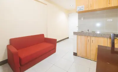a living room with a red couch in a kitchen at J and T Jamich Suites by RedDoorz in Manila