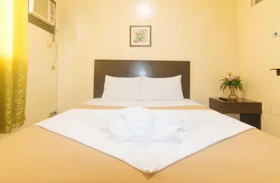 a hotel room with a bed with a towel on it at J and T Jamich Suites by RedDoorz in Manila