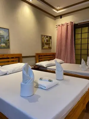 two beds with towels on top of them in a room at P3k suites barkada family room in Manila