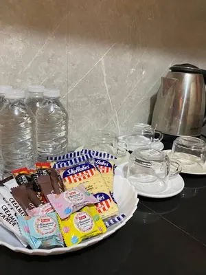 a plate of candy on a table with glasses and bottles of water at P3k suites barkada family room in Manila