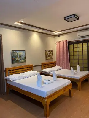 a room with two beds and a window at P3k suites barkada family room in Manila