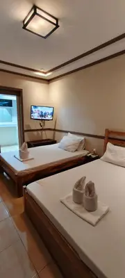 two beds in a room with a tv on the wall at P3k suites barkada family room in Manila
