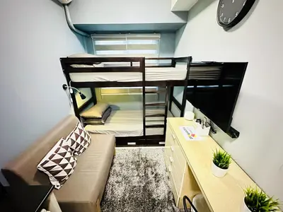 a small room with two bunk beds and a couch at STYLISH LUXE APARTMENT in SMDC GREEN RESIDENCES in Manila