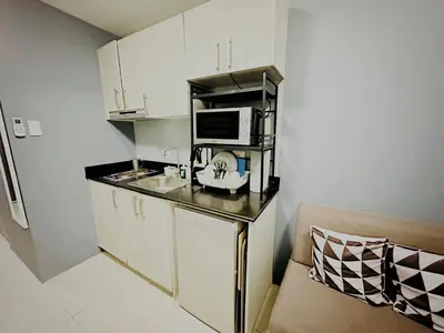 a small kitchen with a counter with a microwave at STYLISH LUXE APARTMENT in SMDC GREEN RESIDENCES in Manila