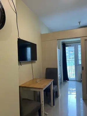 a room with a table and a tv on the wall at Jazz Residences Tower B Makati in Manila