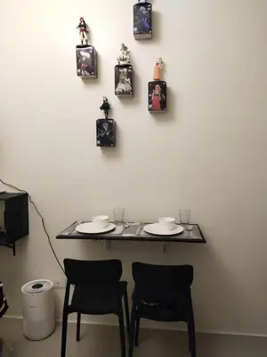 a table with two chairs and pictures on the wall at MJ Luxe Stays in Manila