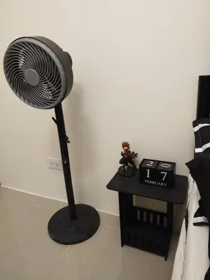 a black fan sitting in a room next to a bed at MJ Luxe Stays in Manila
