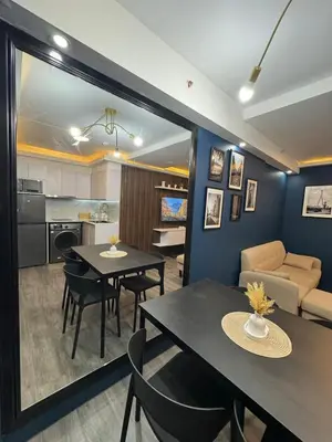 a living room with a dining table and a kitchen at 2BR Apartment in Pasig City in Manila