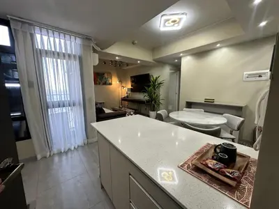 a kitchen and living room with a counter and a table at La nobleza terrazas 2 bedroom condominium in Manila