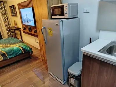 a kitchen with a refrigerator and a microwave on top of it at Modern-Studio with Balcony Stunning View in Manila
