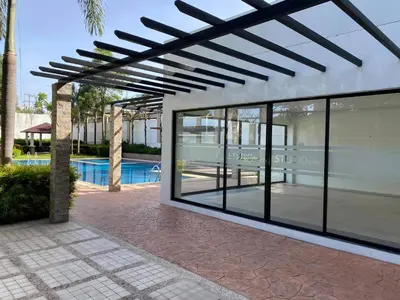 a pergola with glass windows and a swimming pool at Laidback Cavern at Studio City Alabang in Manila