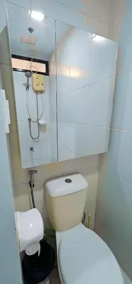 a small bathroom with a toilet and a mirror at Laidback Cavern at Studio City Alabang in Manila