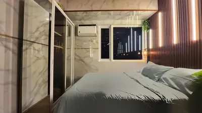 a small bedroom with a bed and a window at Family Suites- Self Service Condo Unit in Jazz Residences Makati in Manila