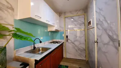 a small kitchen with a sink and a shower at Family Suites- Self Service Condo Unit in Jazz Residences Makati in Manila